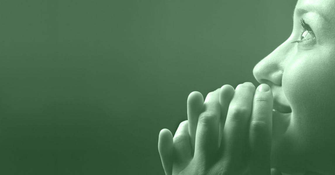 Profile of a woman on right side of image looking up to the left, hands brought to face in awe and/or prayer.