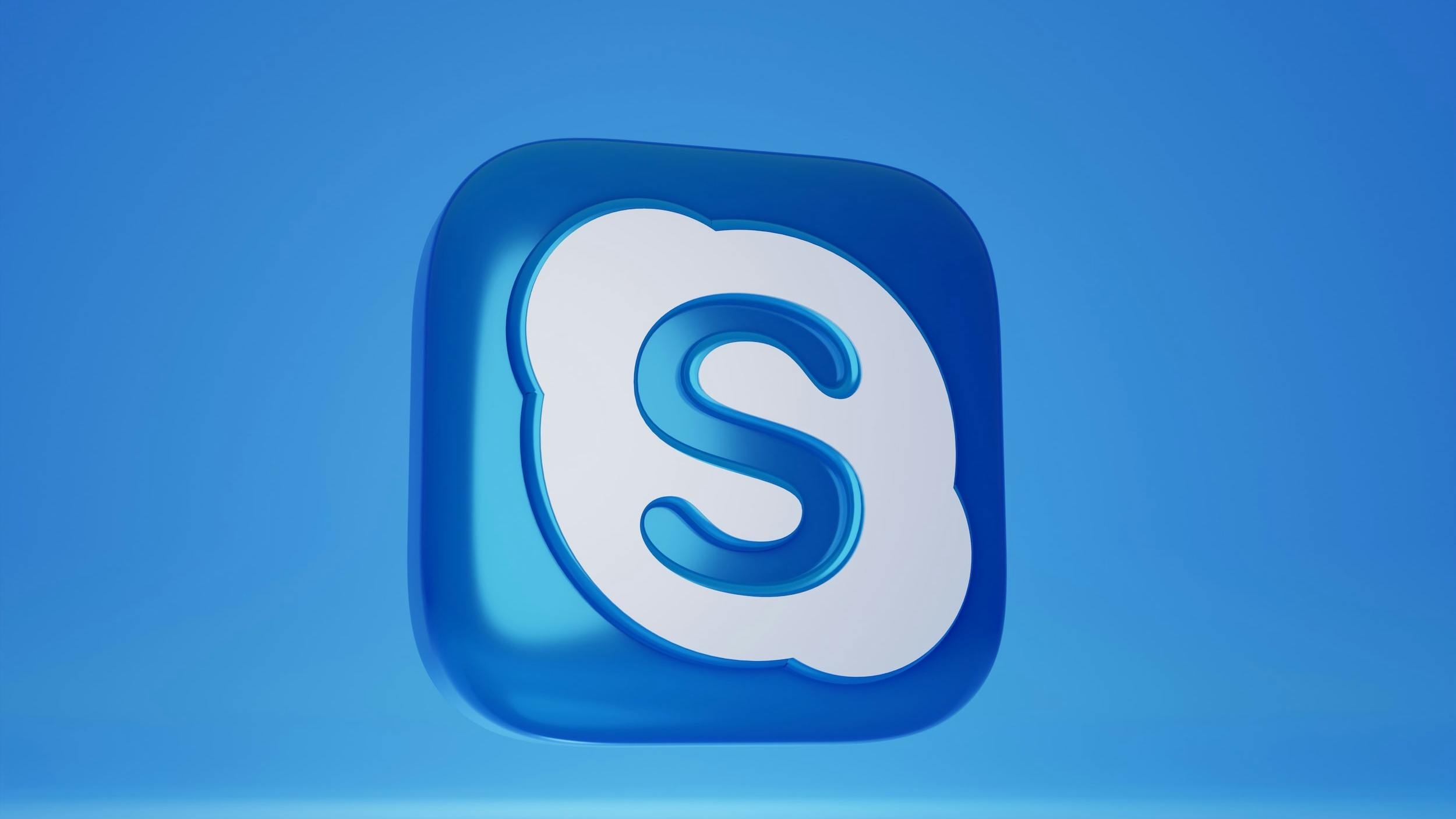 Logo 3D di Skype blu e bianco su sfondo azzurro.