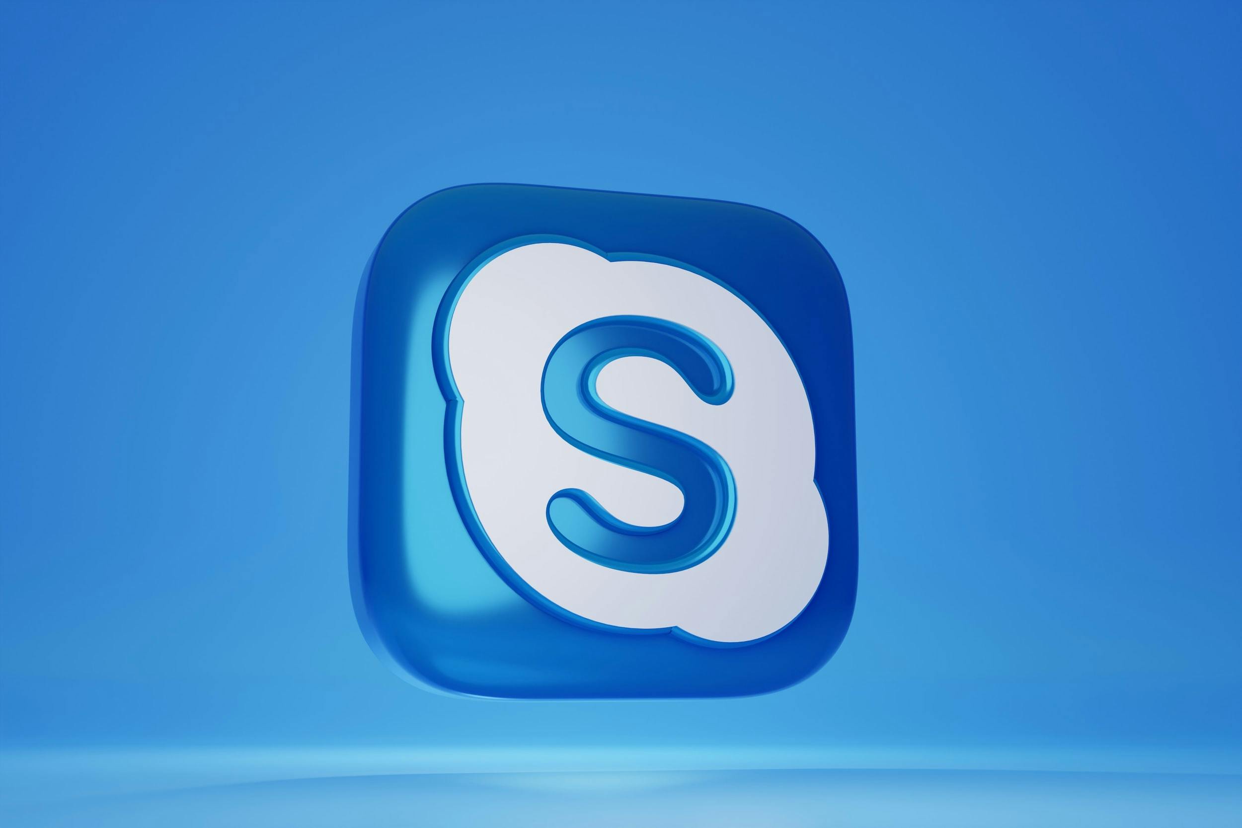 Logo 3D di Skype blu e bianco su sfondo azzurro.