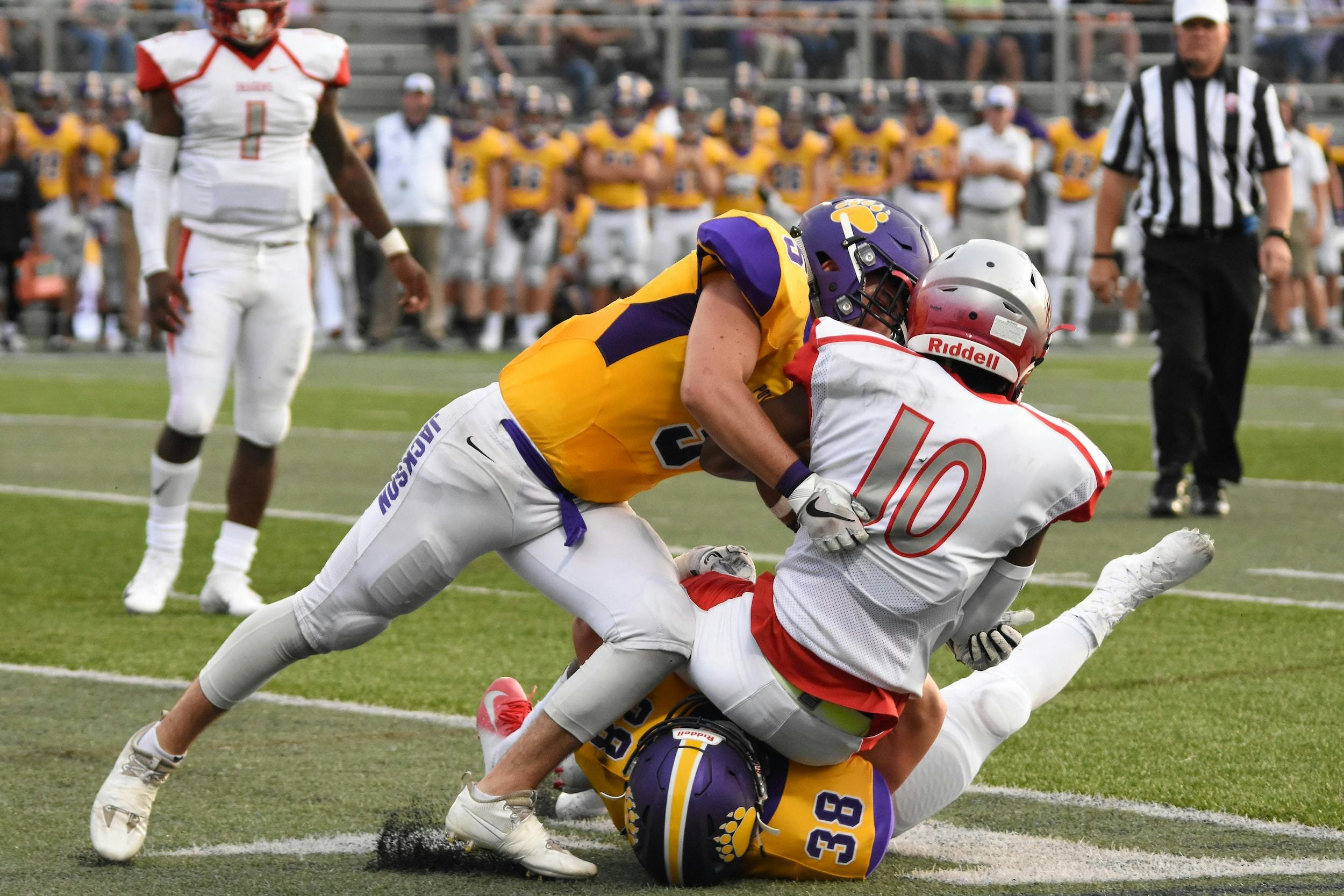 Fotografia di giocatori di football americano durante un placcaggio.