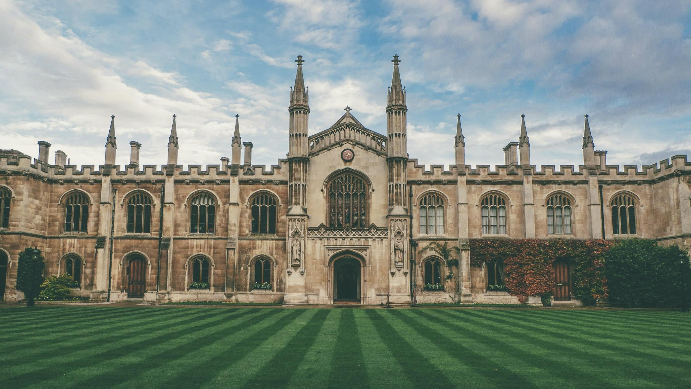 Edificio storico dell'Università di Cambridge fotografato in una giornata di cielo azzurro.