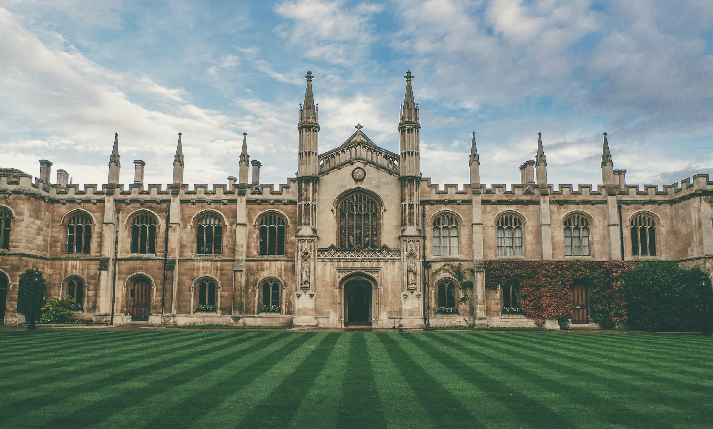 Historic building of the University of Cambridge photographed on a blue sky day.