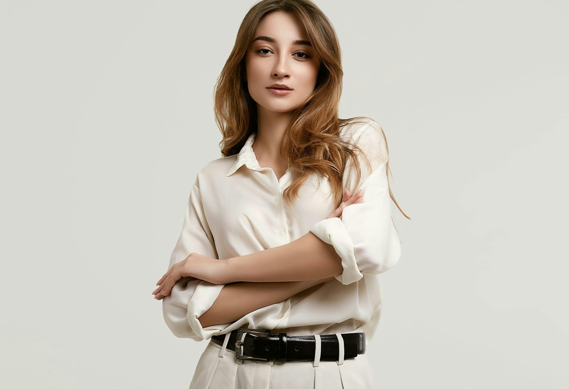 woman in a white shirt and tan pants posing for a picture