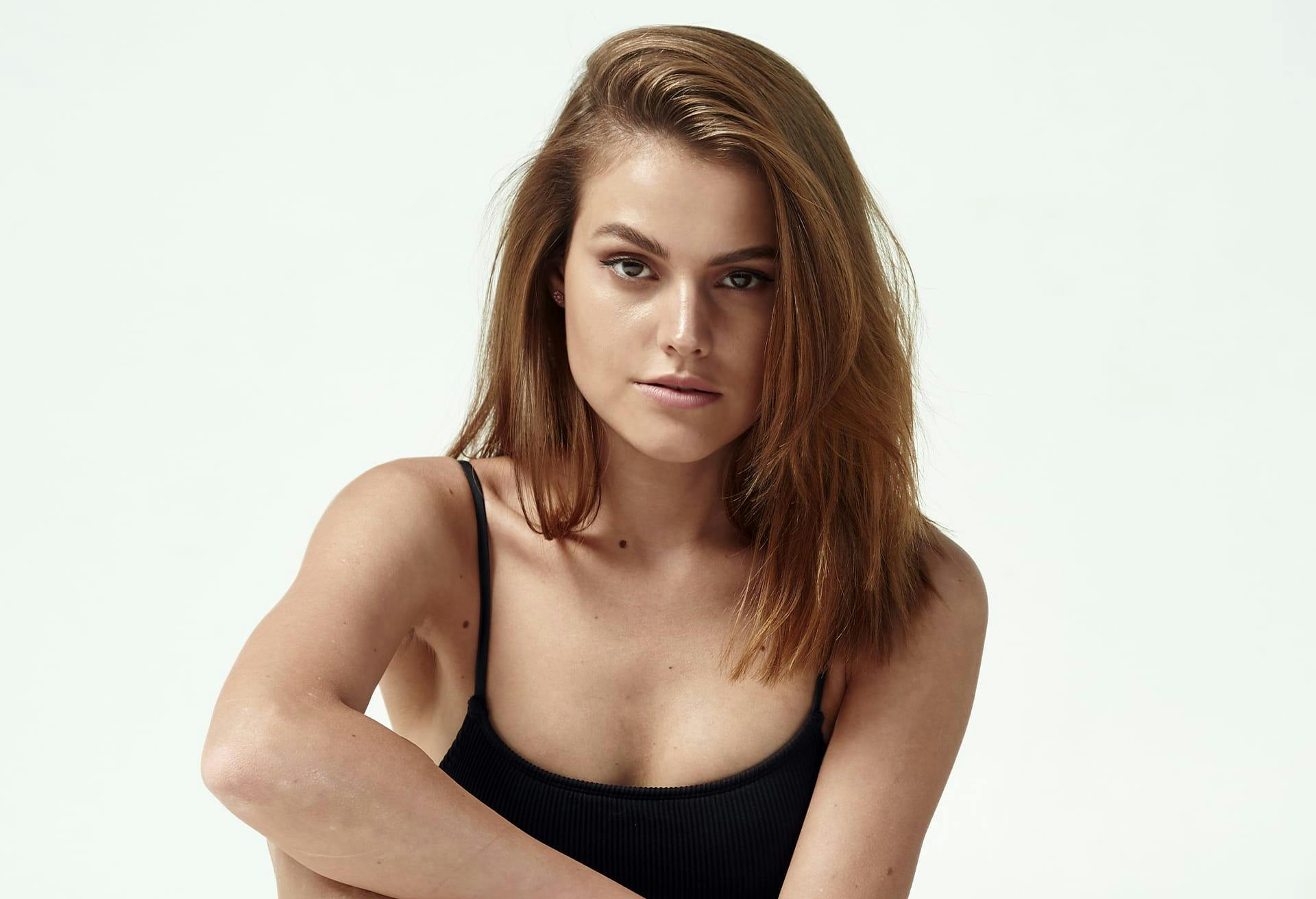 woman in a black top and jeans posing for a picture