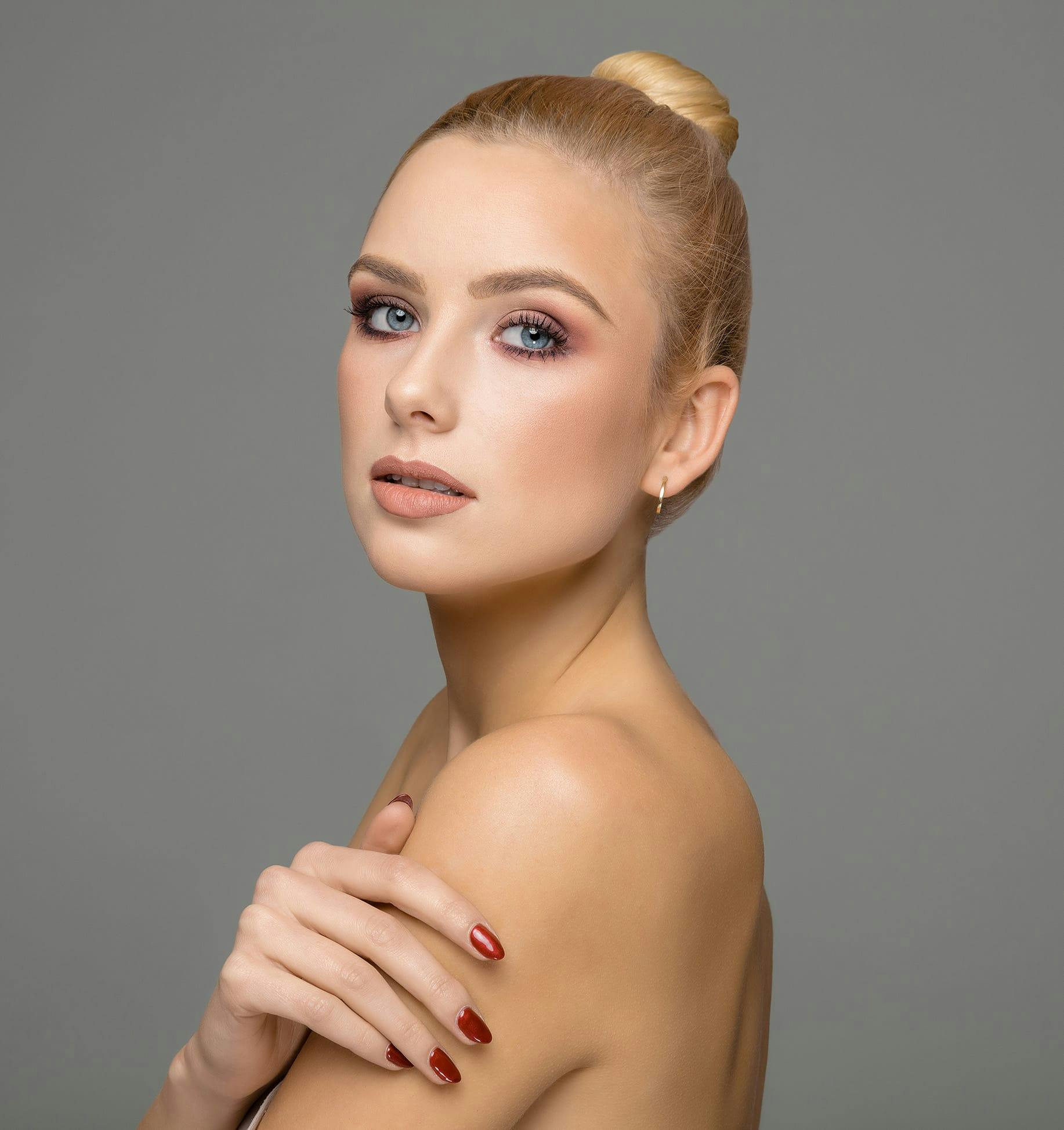blonde woman in bun and hand on arm