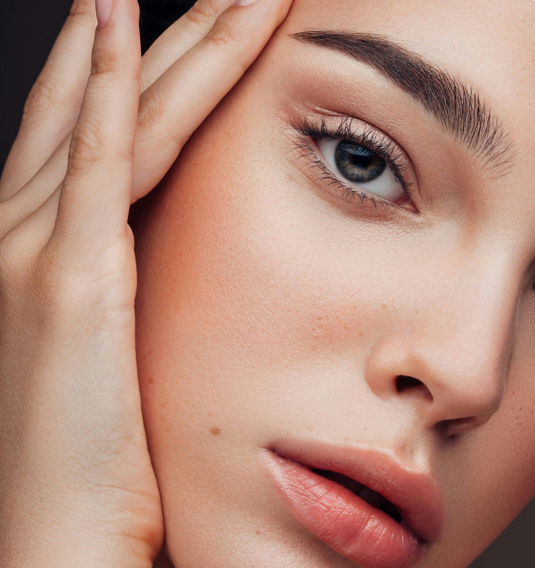 close up of woman's hand on face