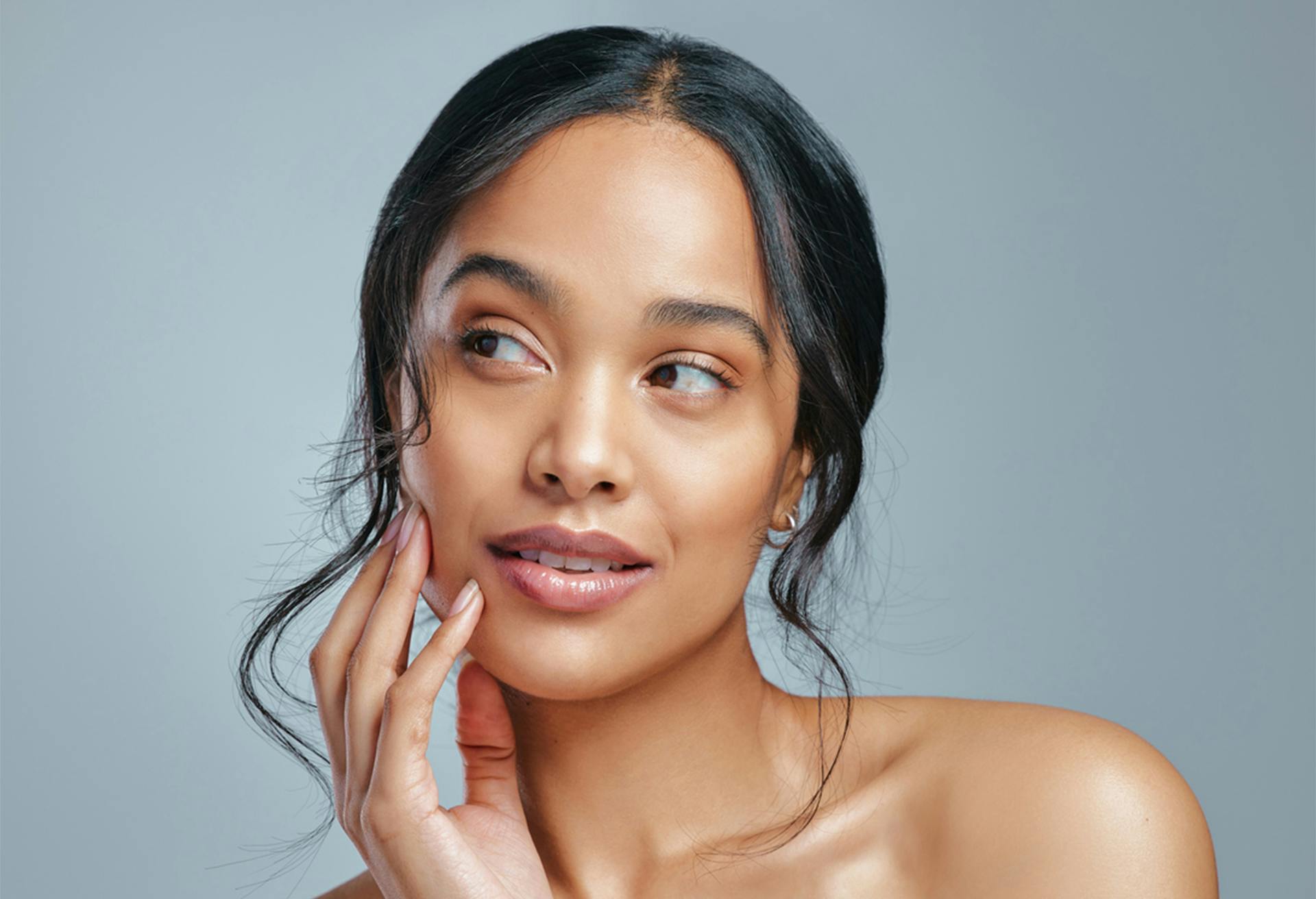 woman touching face and looking to the side