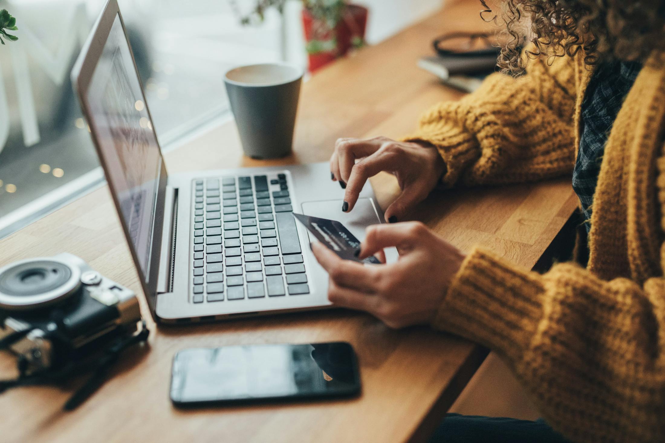 someone is using a laptop and a cell phone on a desk