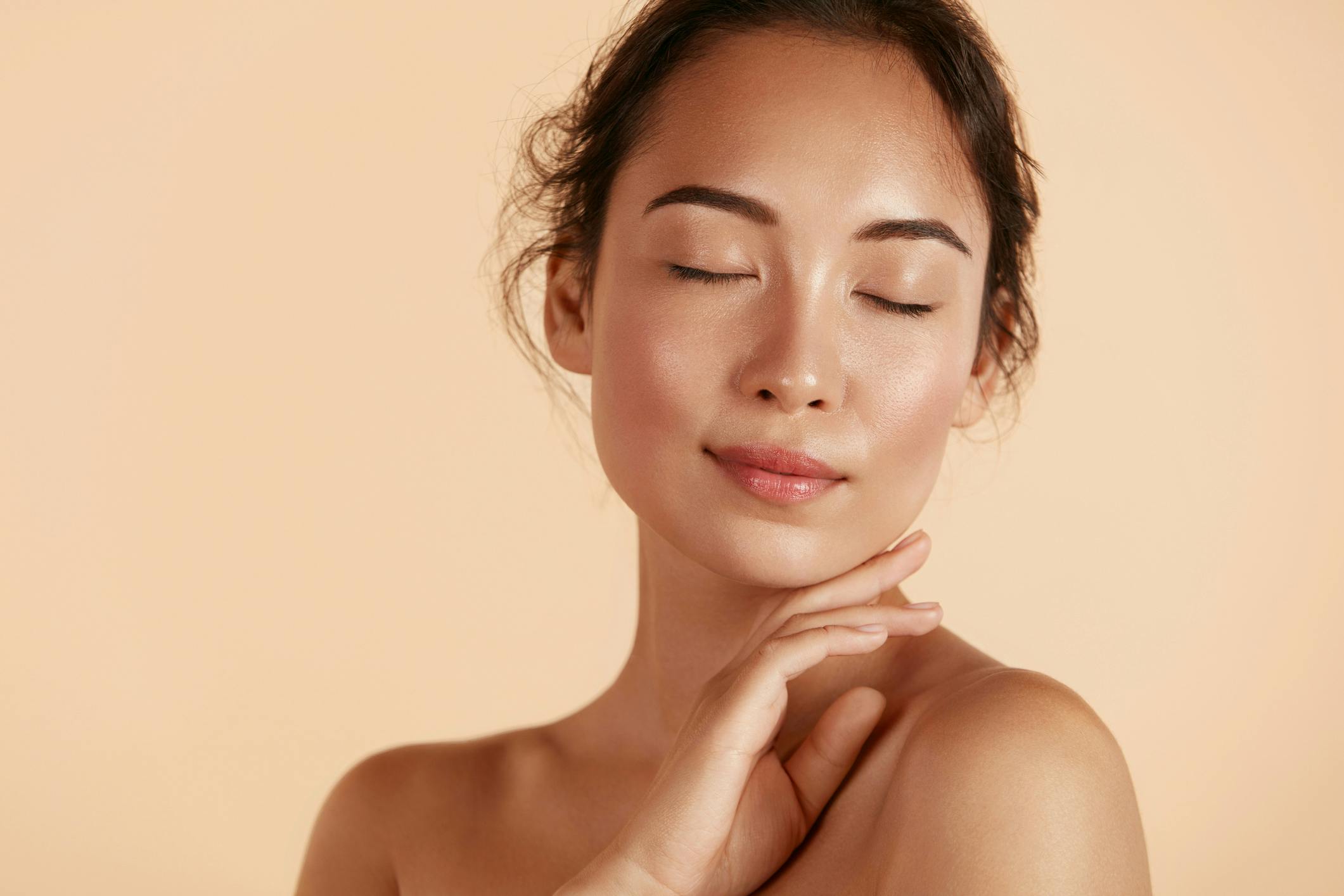 woman with her eyes closed and her hand on her chin