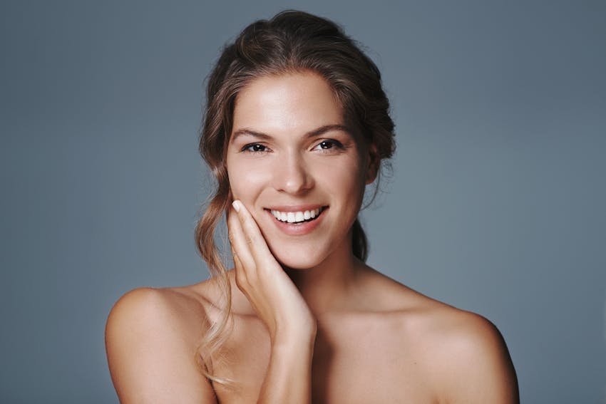 Smiling woman with hand on chin and hand on chin