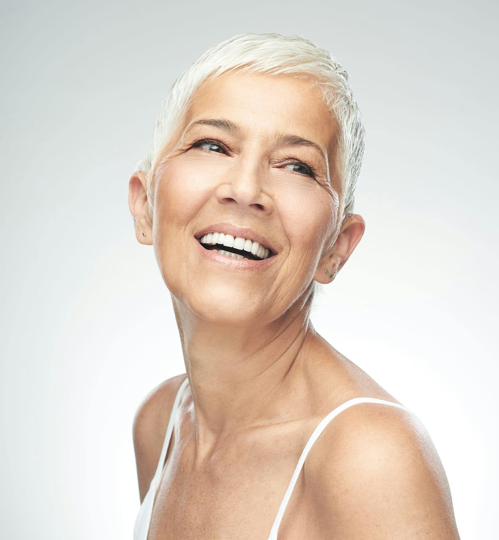 older woman with very short grey hair smiling