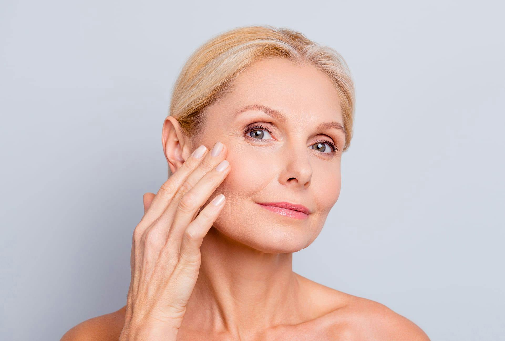 Beautiful older woman touching her face