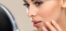 female checking pores in mirror