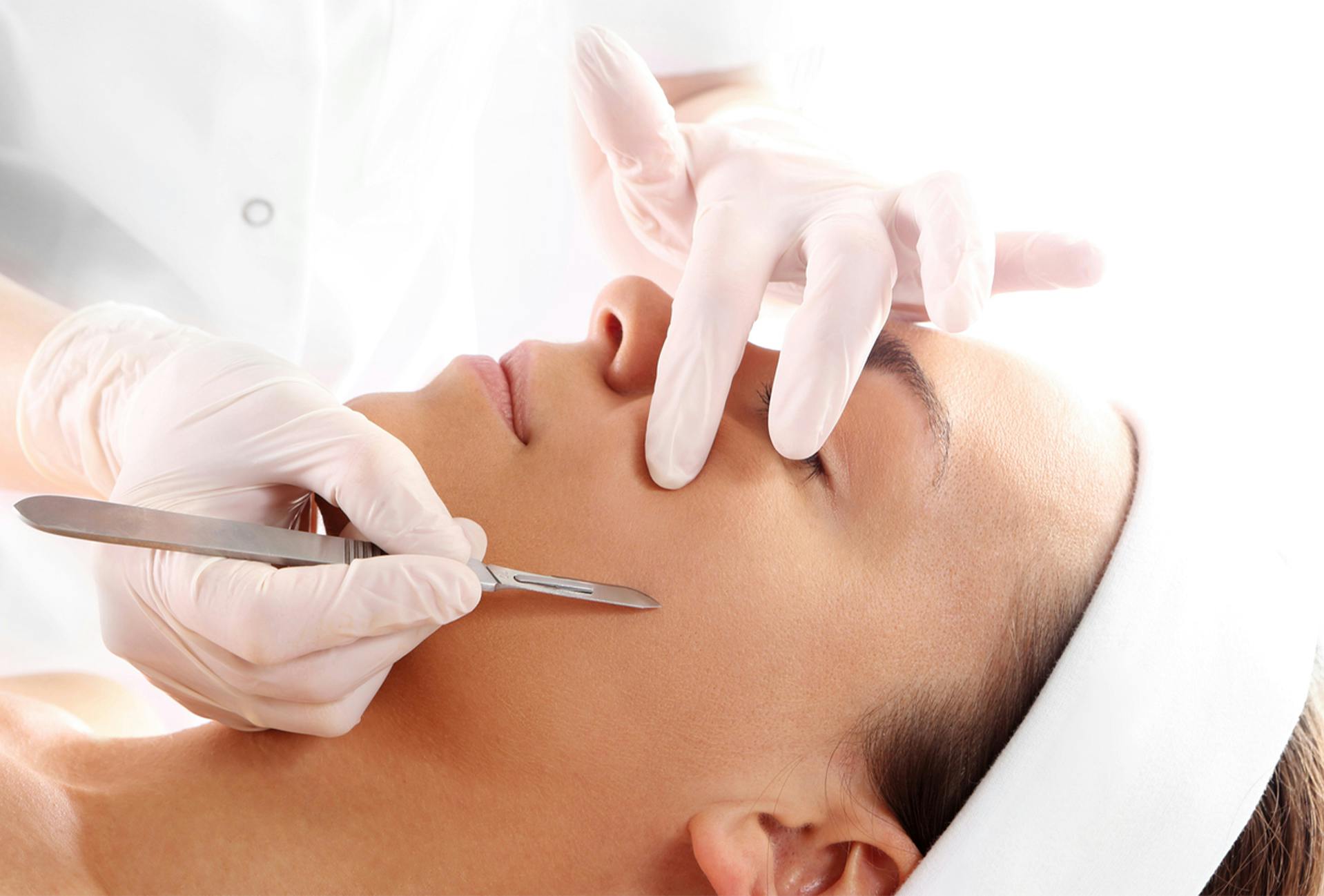 Woman receiving dermaplaning treatment at The Dermatology Center