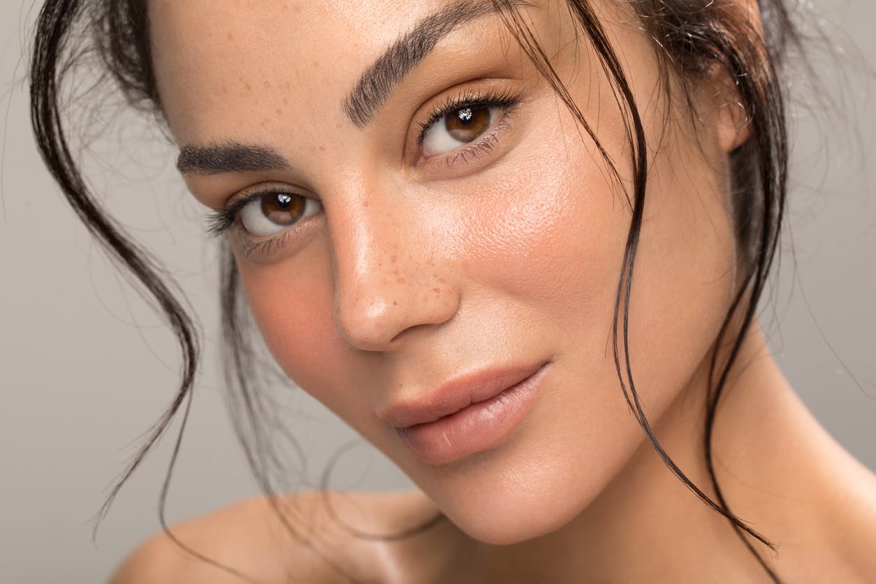 Woman in portrait shoot, close up of face with gorgeous healthy skin shows the potential results of having AVAVA Treatments in a studio shoot