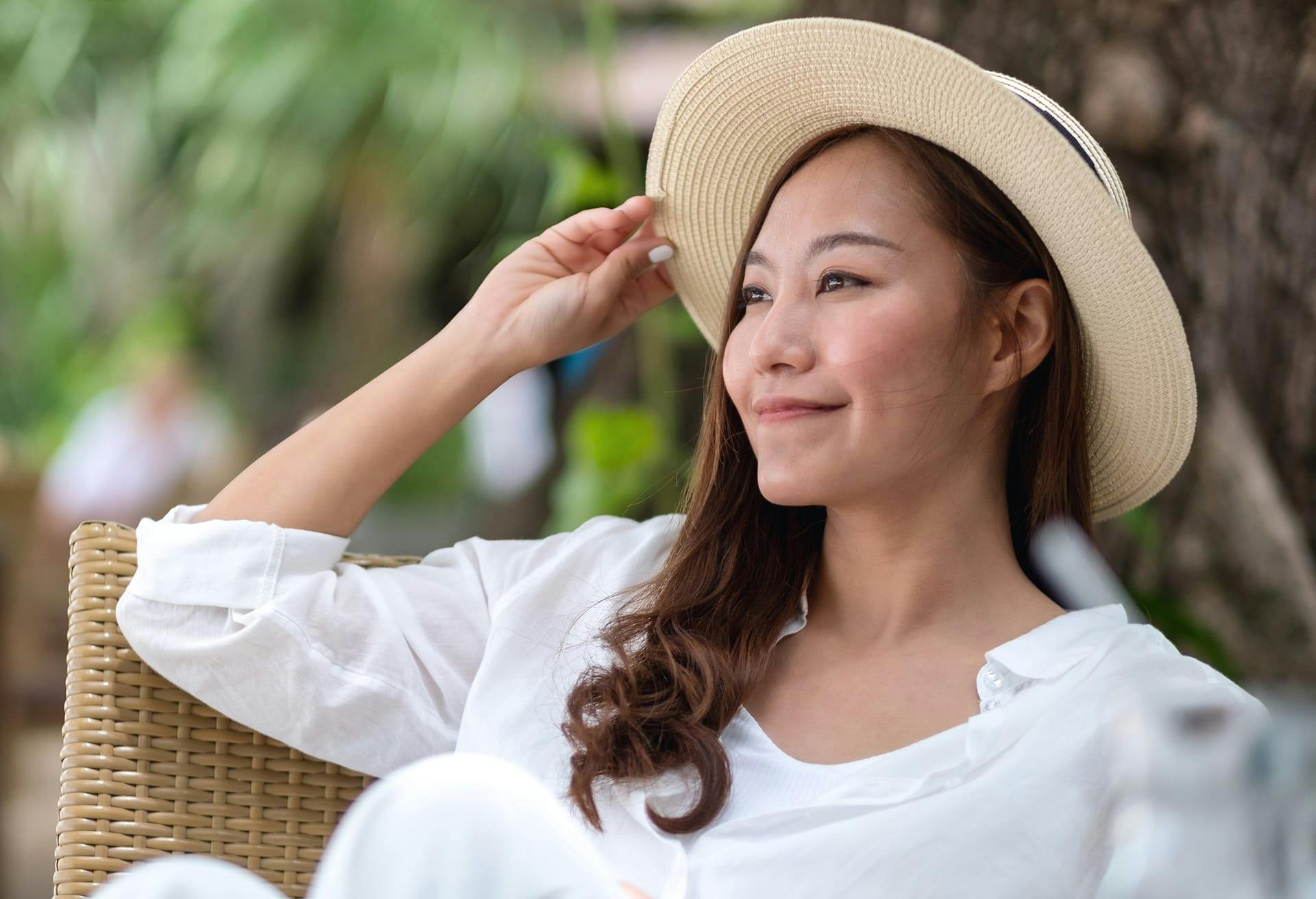 Woman Sitting Outside with a Sun Hat On