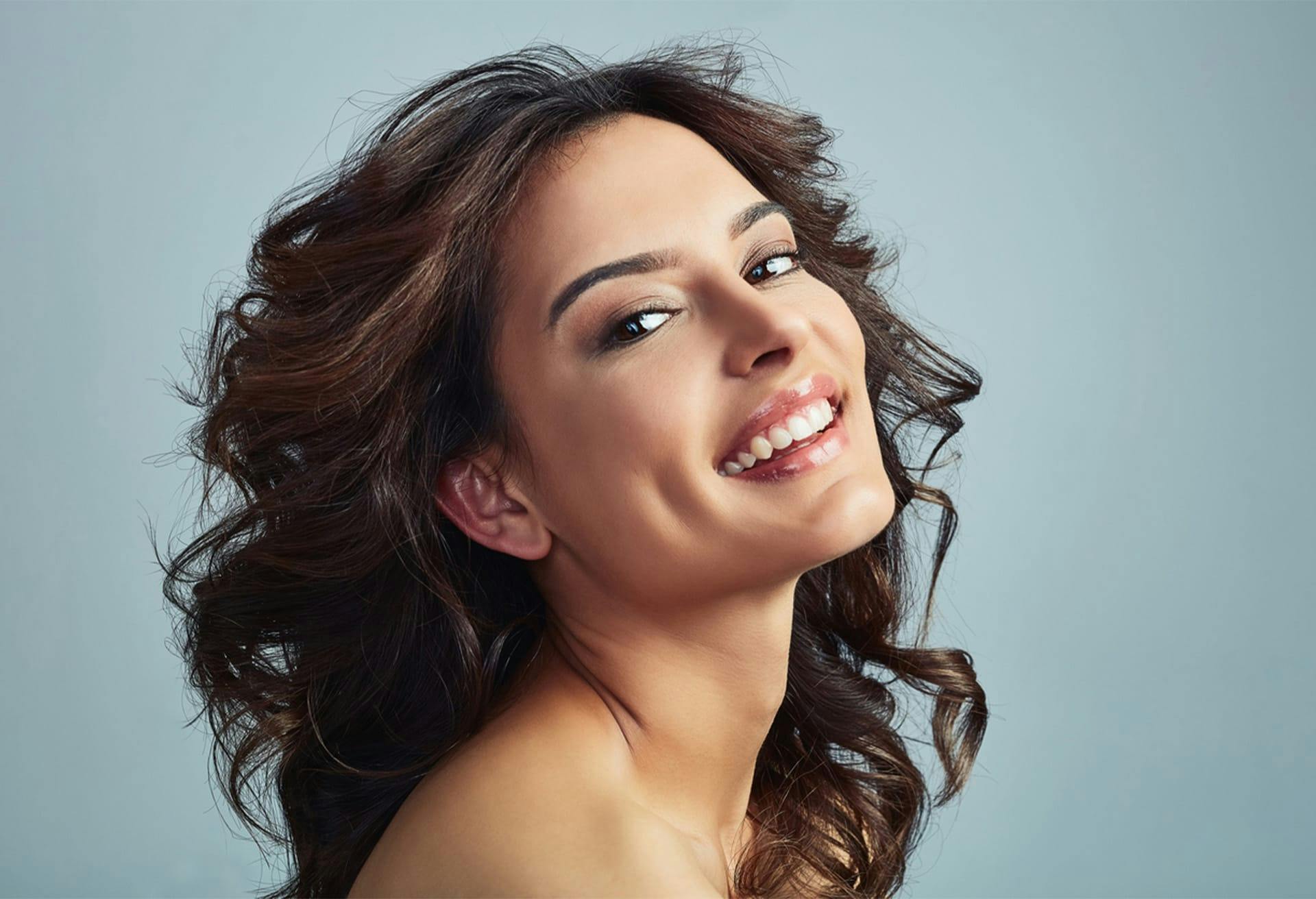 Woman Smiling with Curly Brown Hair