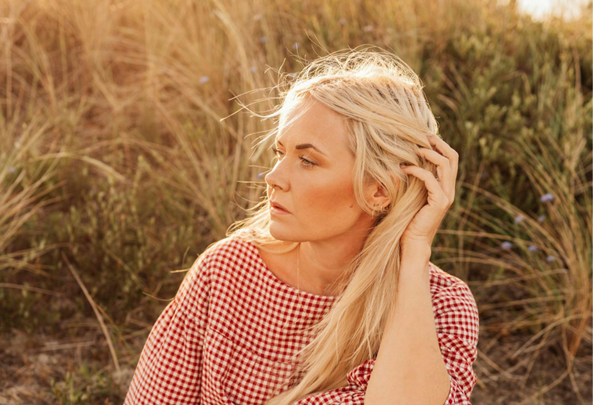 Blond Woman Posing in Front of Bushes