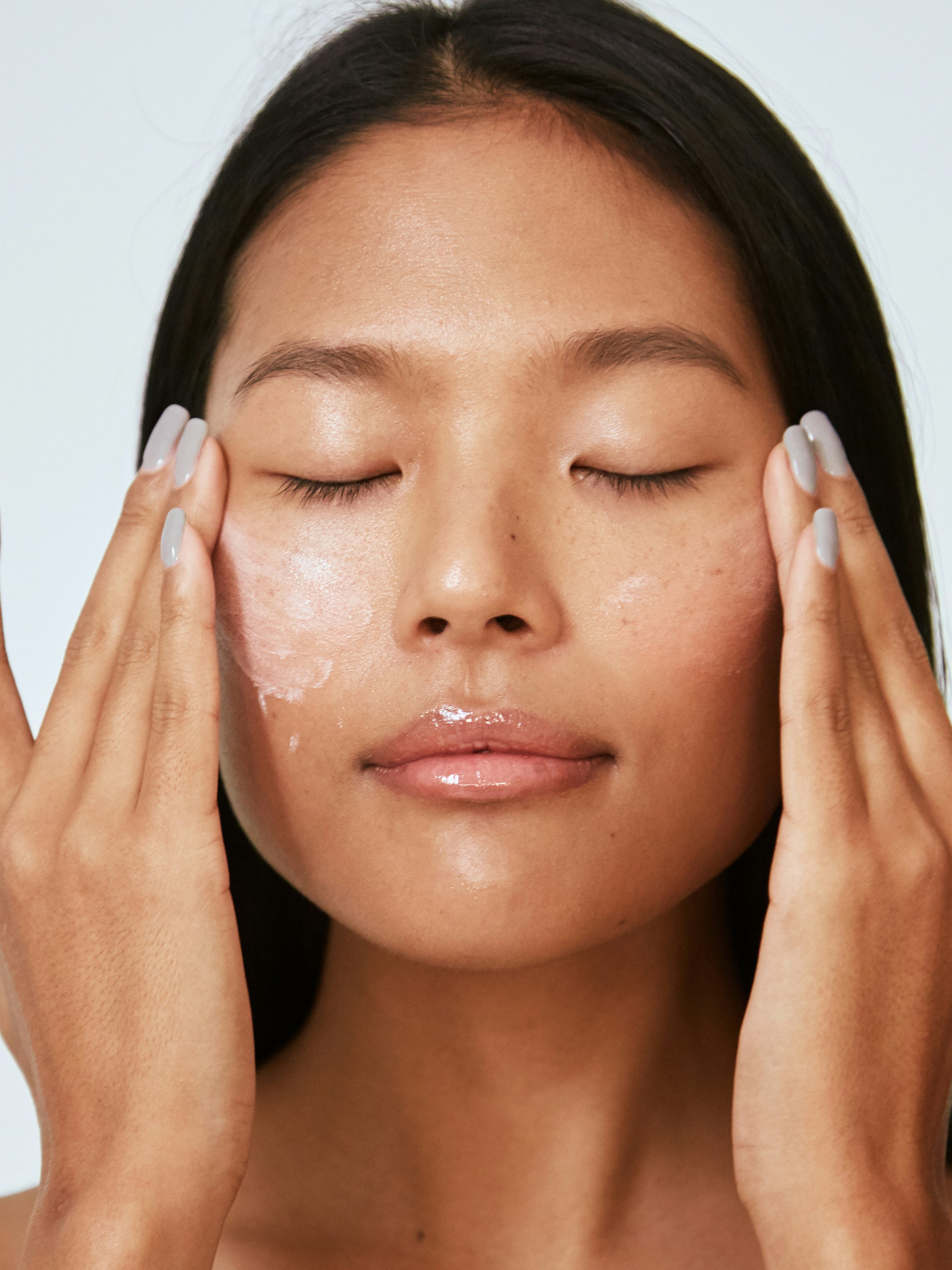 how to take care of your skin after aesthetic treatments woman applying skincare products to face