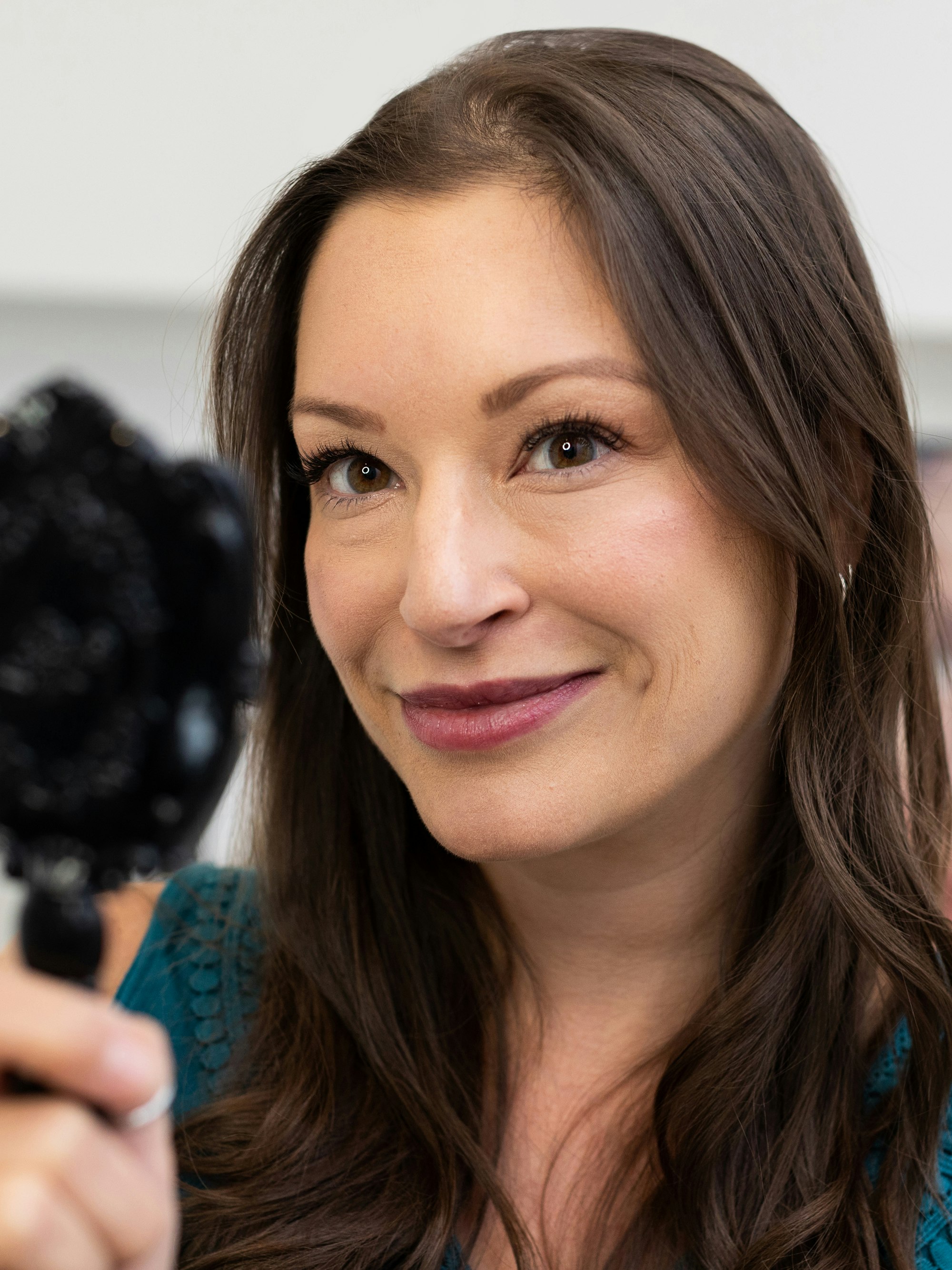 woman looking into mirror with eyelash extensions