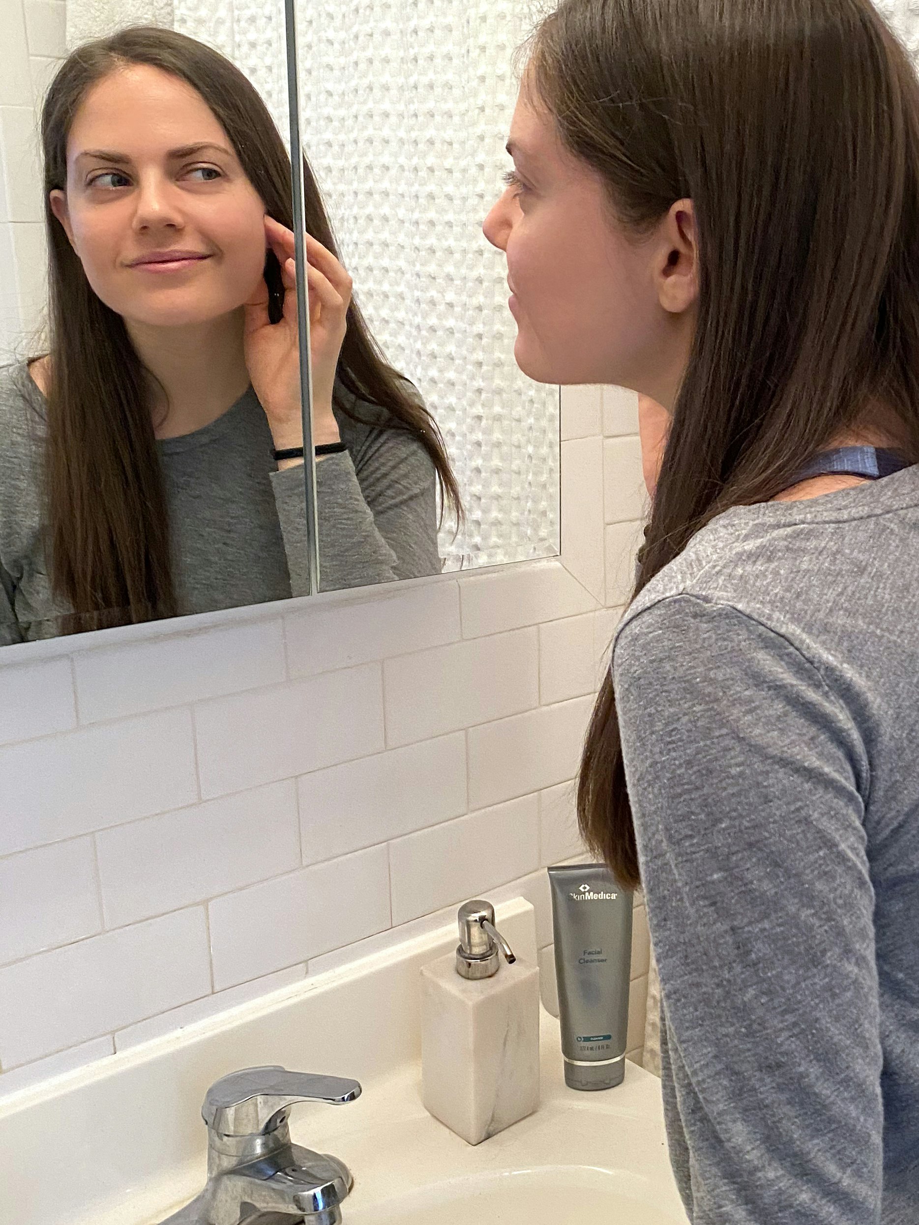 hilary looking at skin concerns in mirror