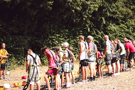Op deze afbeelding is te zien hoe de groep zich klaarmaakt om te gaan klimmen in het klimpark tijdens het zomerkamp Breinspoken.