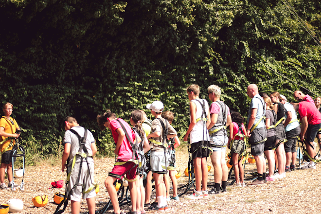 Op deze afbeelding is te zien hoe de groep zich klaarmaakt om te gaan klimmen in het klimpark tijdens het zomerkamp Breinspoken.