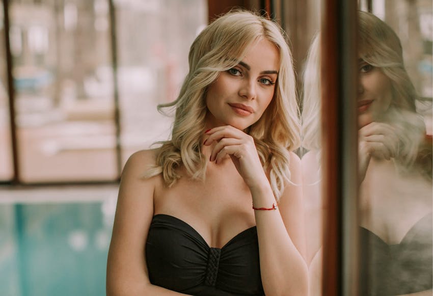 Blonde Woman Leaning Against a Glass Door
