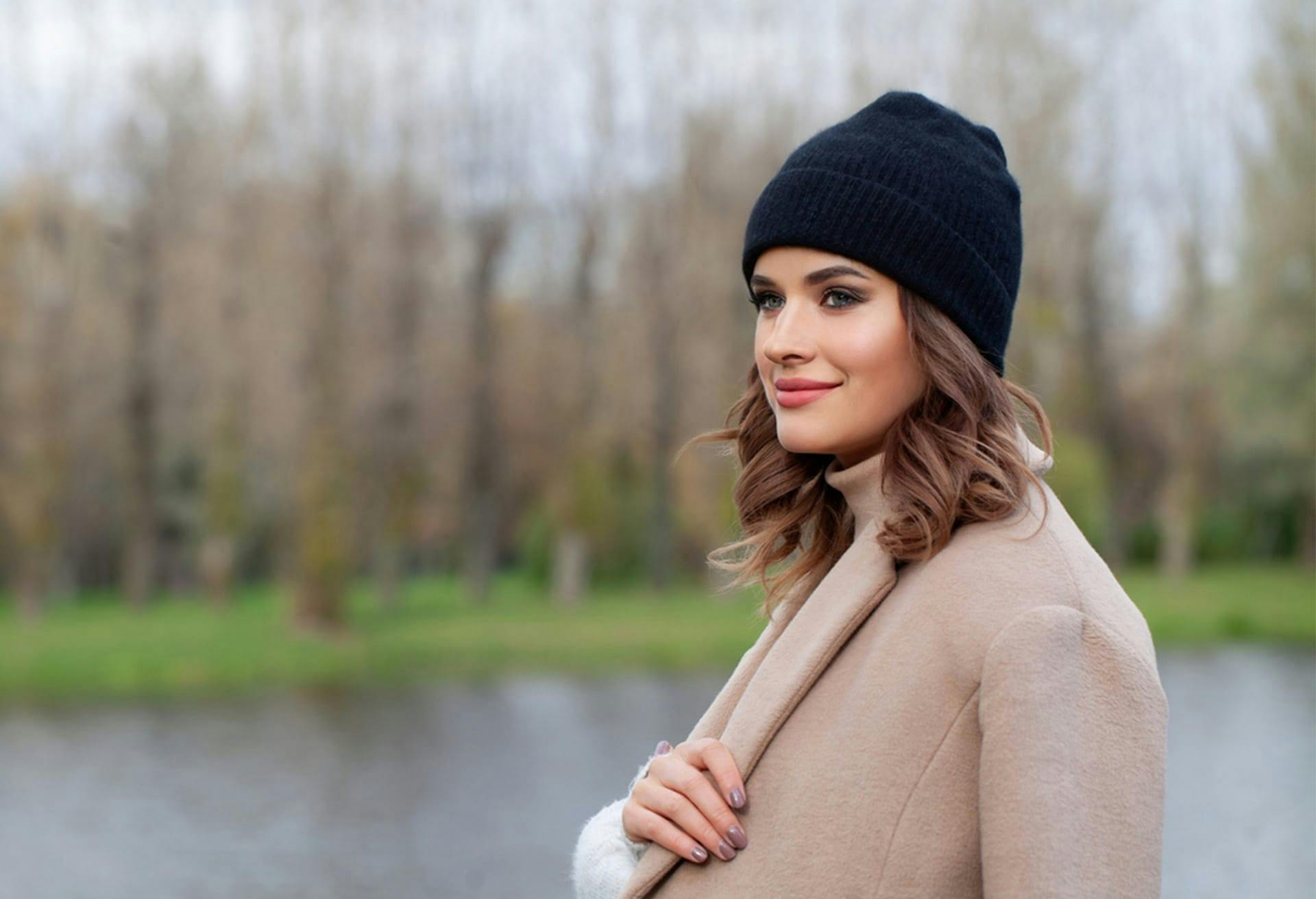 Woman Standing Outside with Black Beanie and Beige Coat