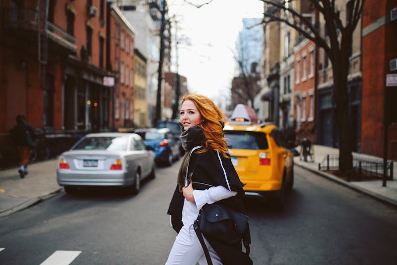 woman in a black sweater crossing the street