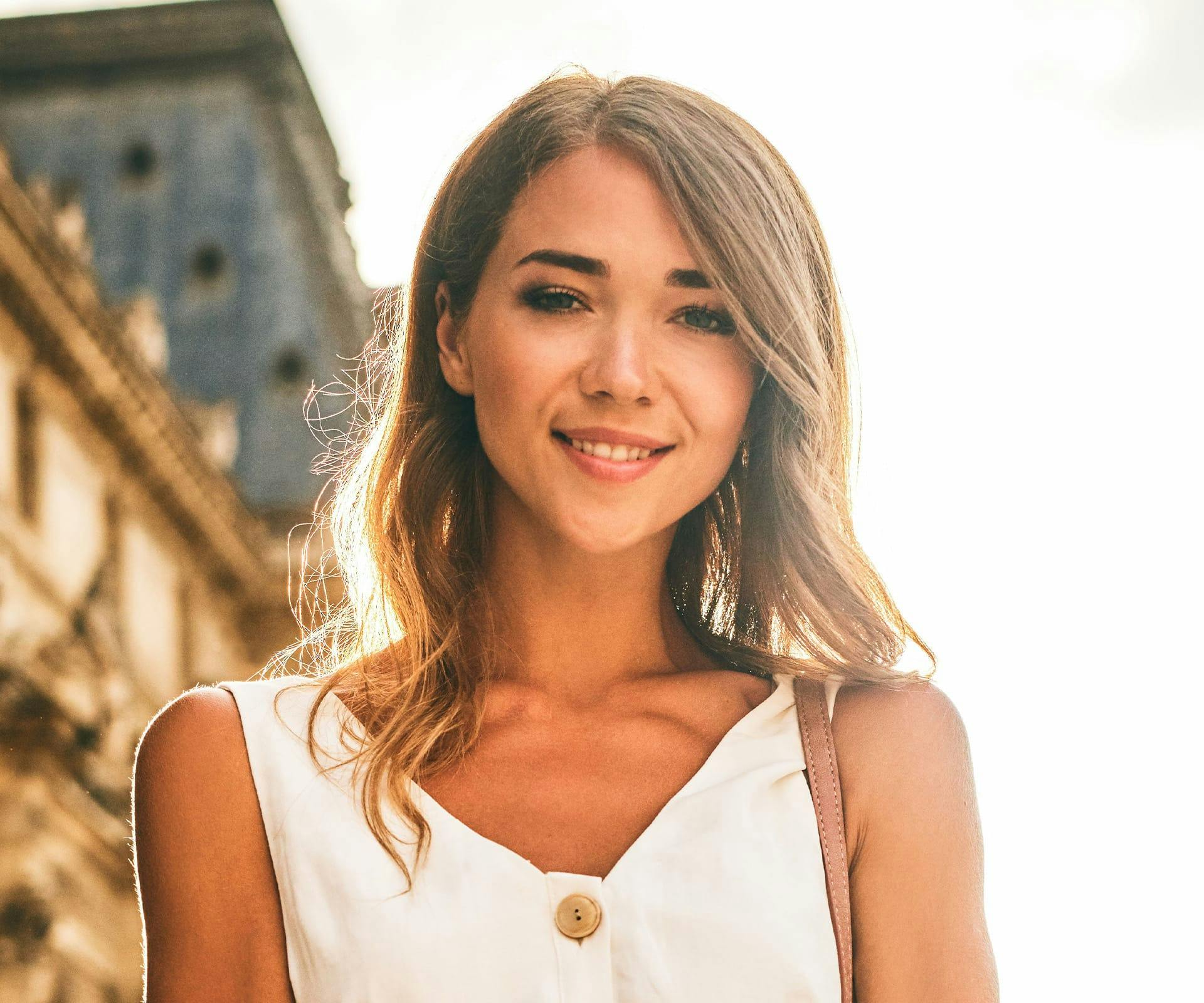 a woman smiling in the sun after getting a root canal in Hilton Head and Bluffton