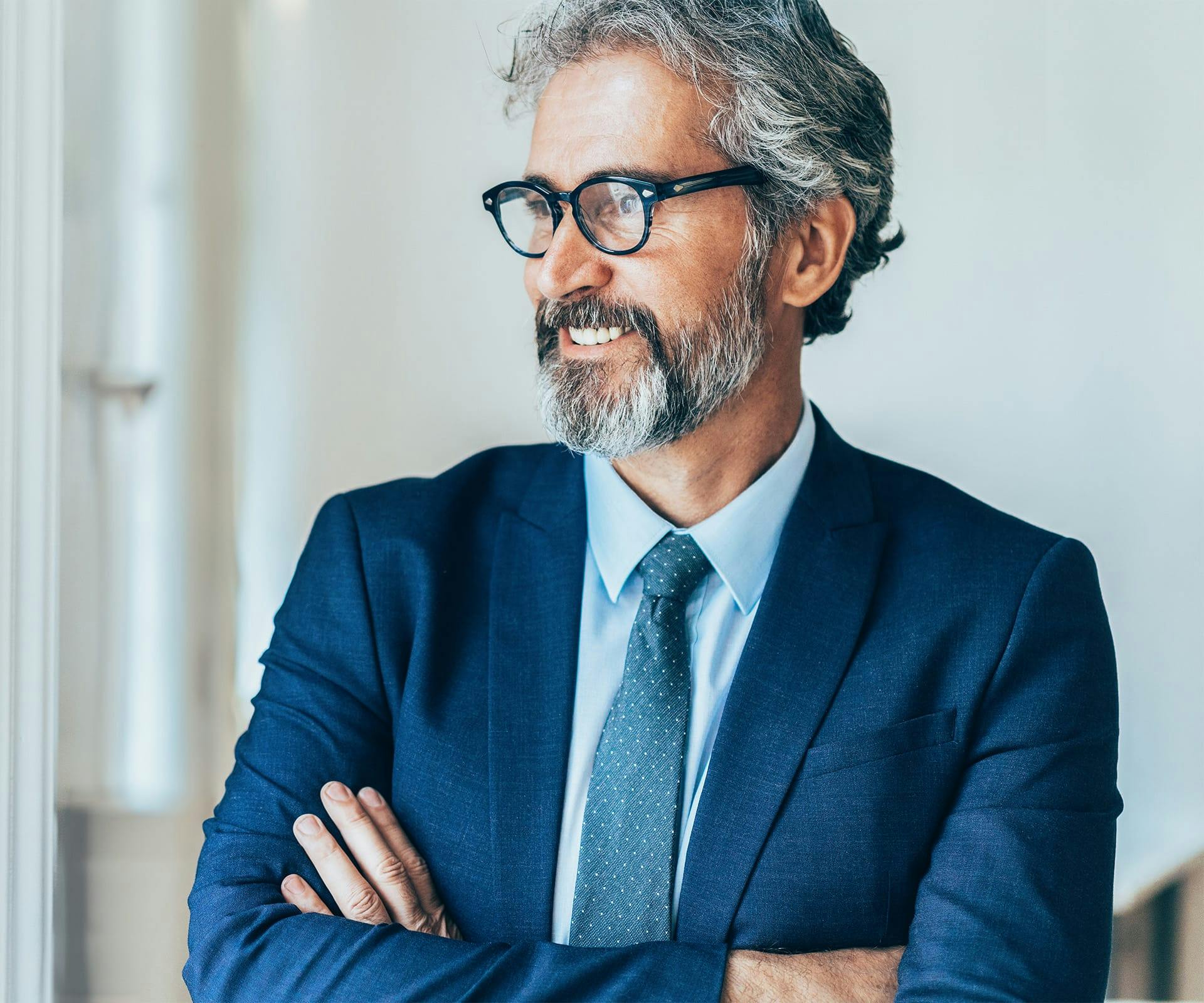 man in suit crossing his arms looking to the left