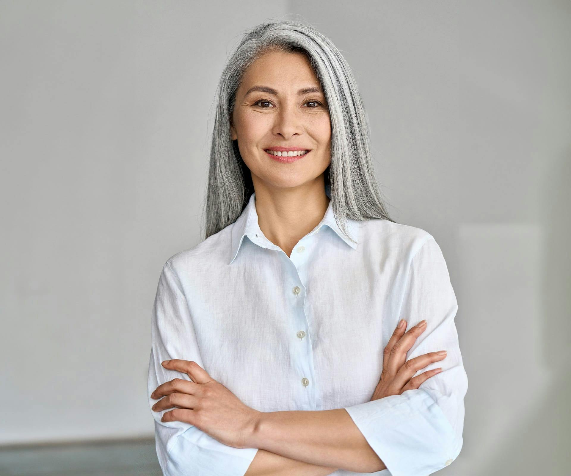 woman with gray hair crossing her arms