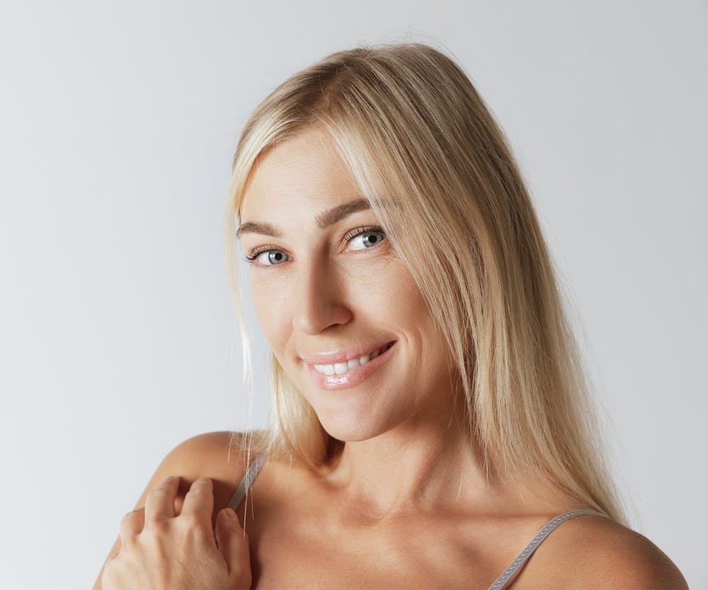 a woman smiling after getting a dental bridge in Hilton Head and Bluffton
