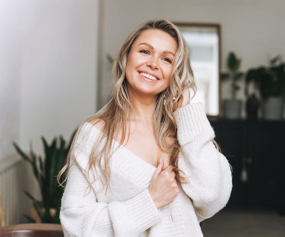 woman with blonde hair in white cardigan