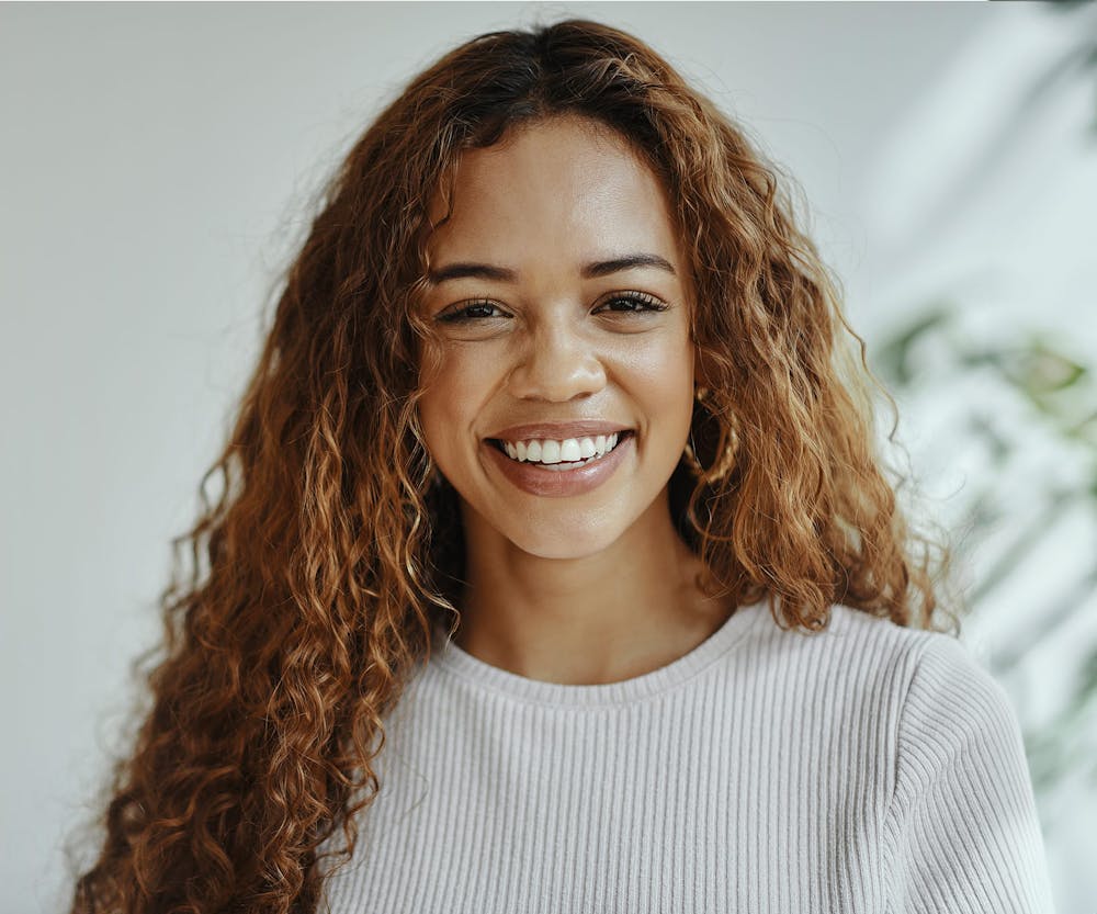 woman with curly hair smiling forward