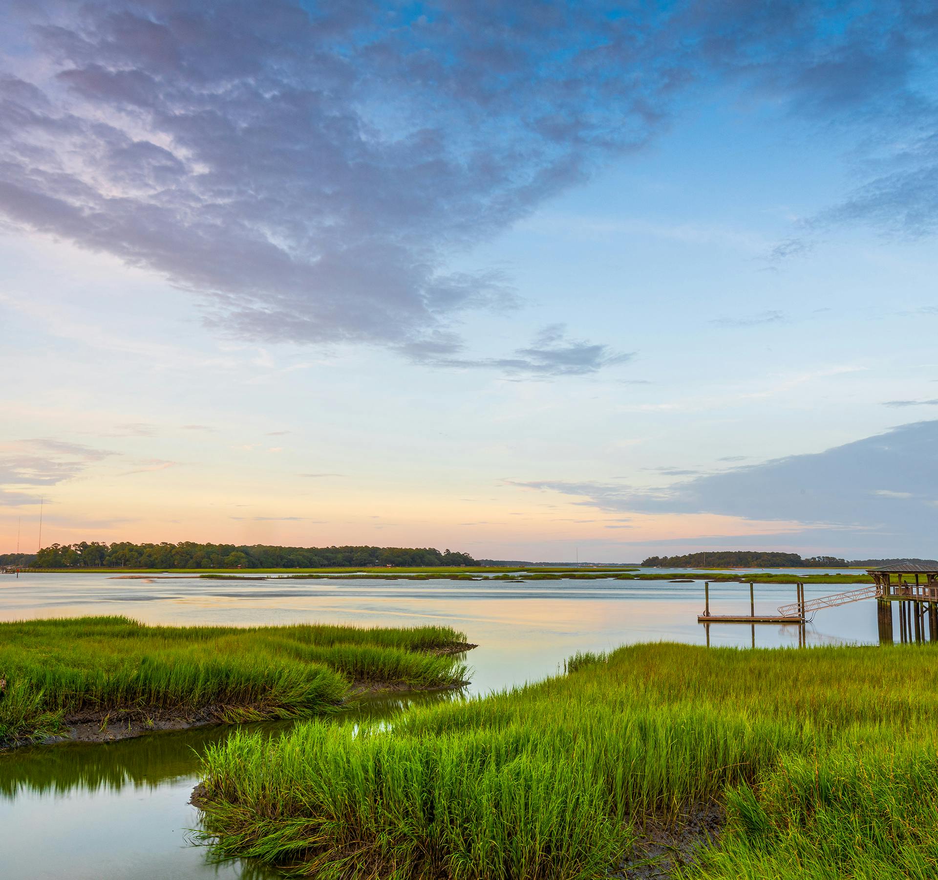 sunset on a lake with a dock on the right