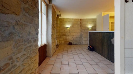 <p>38 000 € de travaux | 7 800 € d'ameublement</p><p id="">On fait souvent des miracles en optimisant l'espace et en déplaçant certains éléments.&nbsp;Ici, en déplaçant légèrement la cuisine, celle-ci offre soudainement une impression d'espace beaucoup plus marquée, aidée en cela par la montée en gamme de l'équipement et des revêtements.<br>Côté salon, on se débarrasse du carrelage qui contrastait fortement avec l'impression de chaleur émanant des murs en pierre. L'apparition d'une cloison entre l'espace à vivre et le côté chambre fait gagner l'appartement en maturité et en cachet. Évidemment, la salle de bain est reprise de fond en combles pour un effet (et de l'équipement) plus moderne.</p>