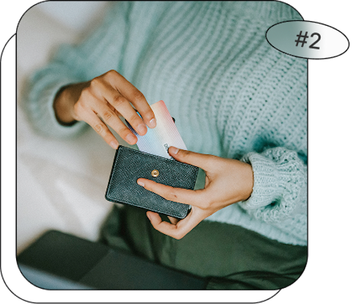 zoom sur les mains d'une personne qui attrape sa carte bancaire de son portefeuille