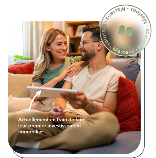 couple assis dans un canapé avec une tablette dans les mains