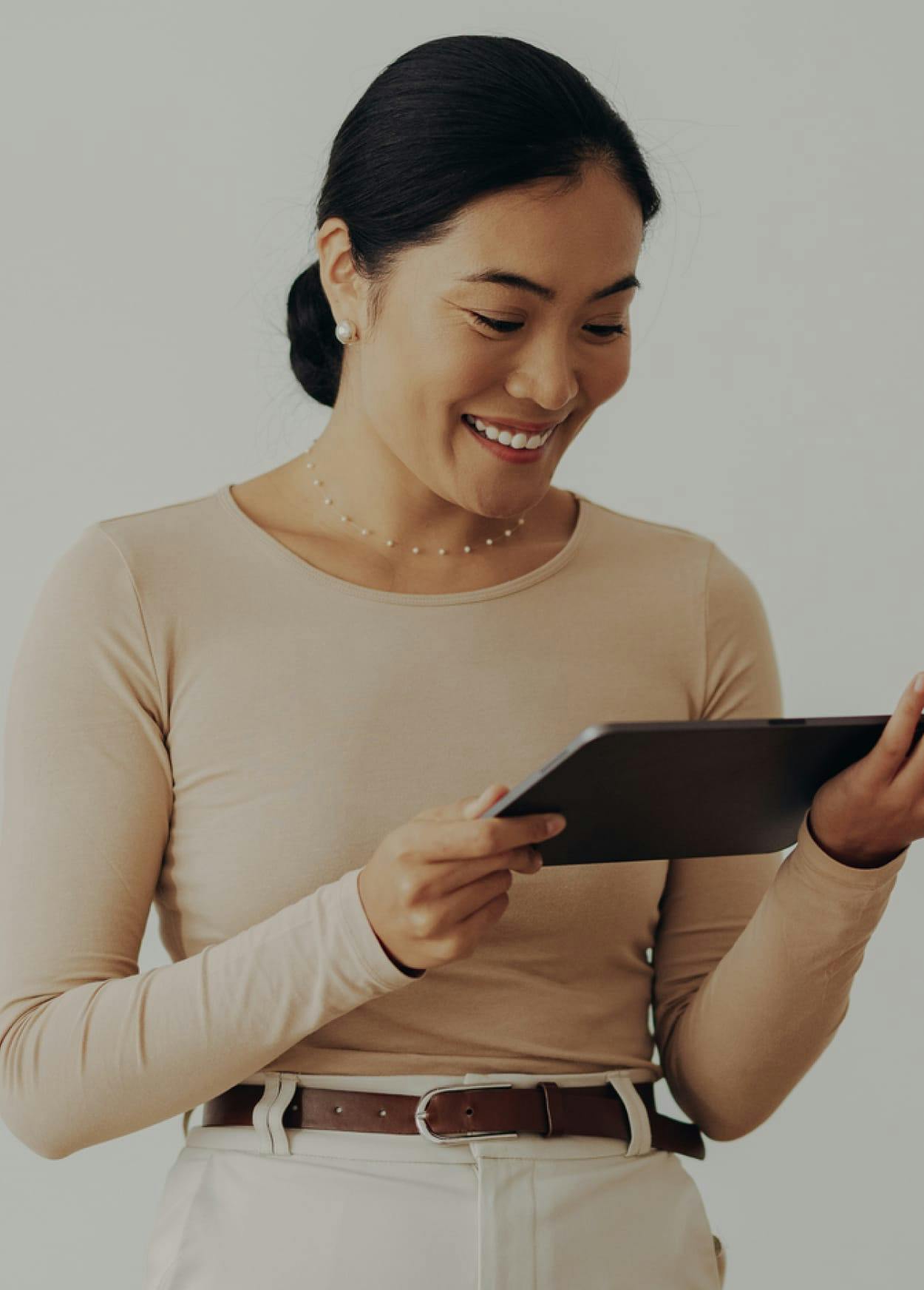 Smiling woman looking at a tablet.