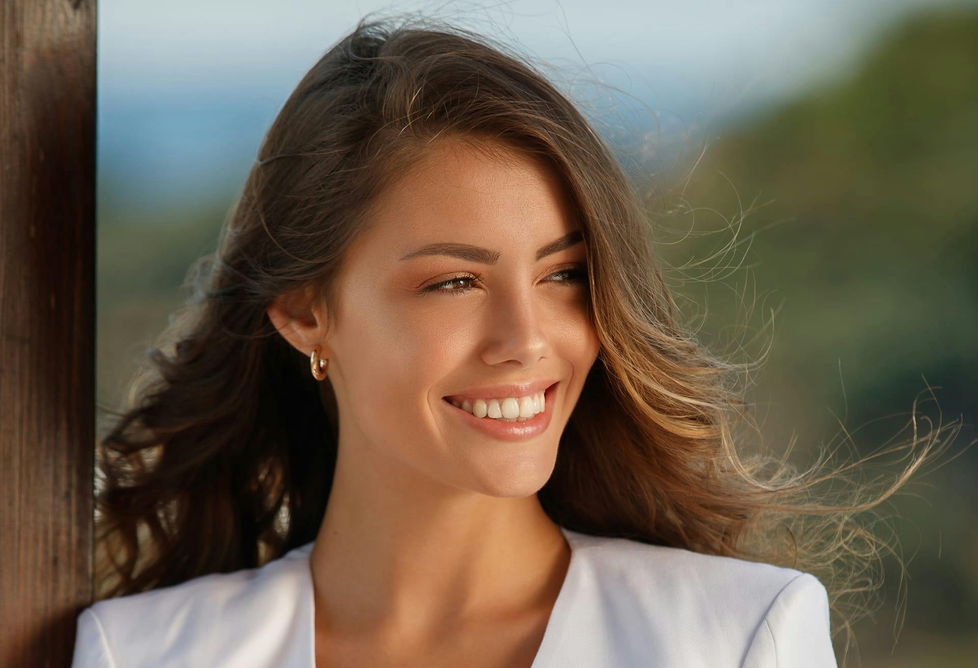 Woman smiling while her hair is being blown back by the wind