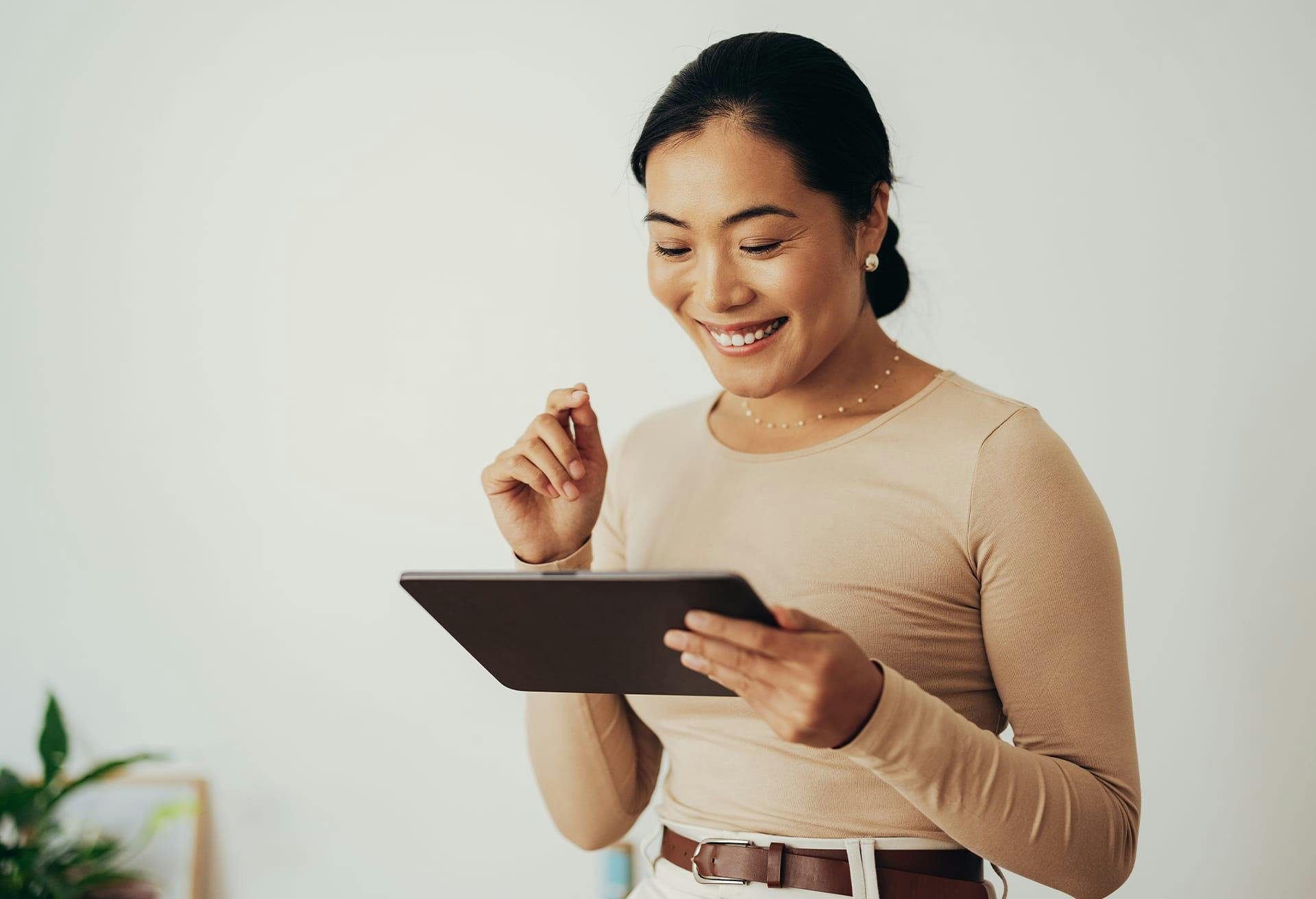 Asian woman looking at a black tablet
