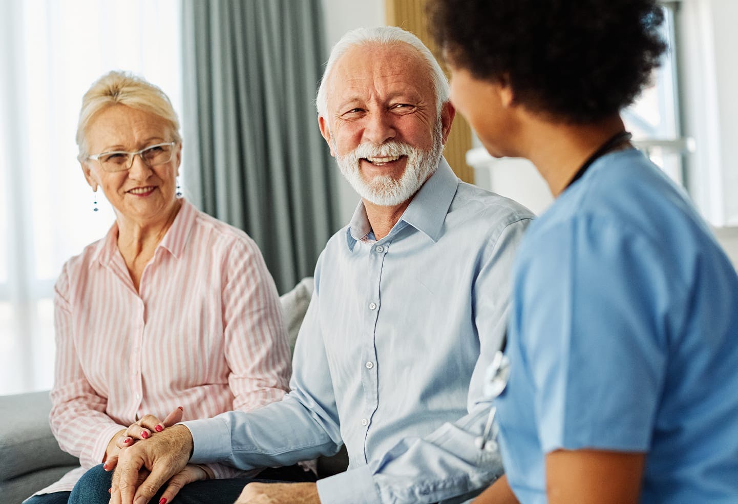 Older couple smiling while talking to a medical provider