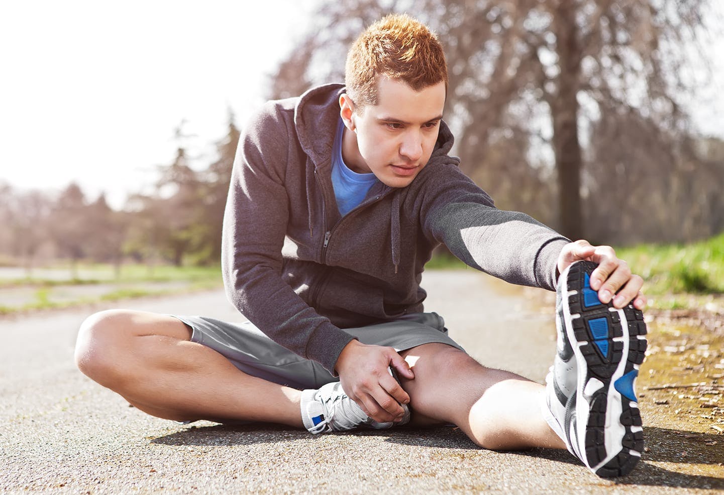 Man sitting down stretching his legs outside