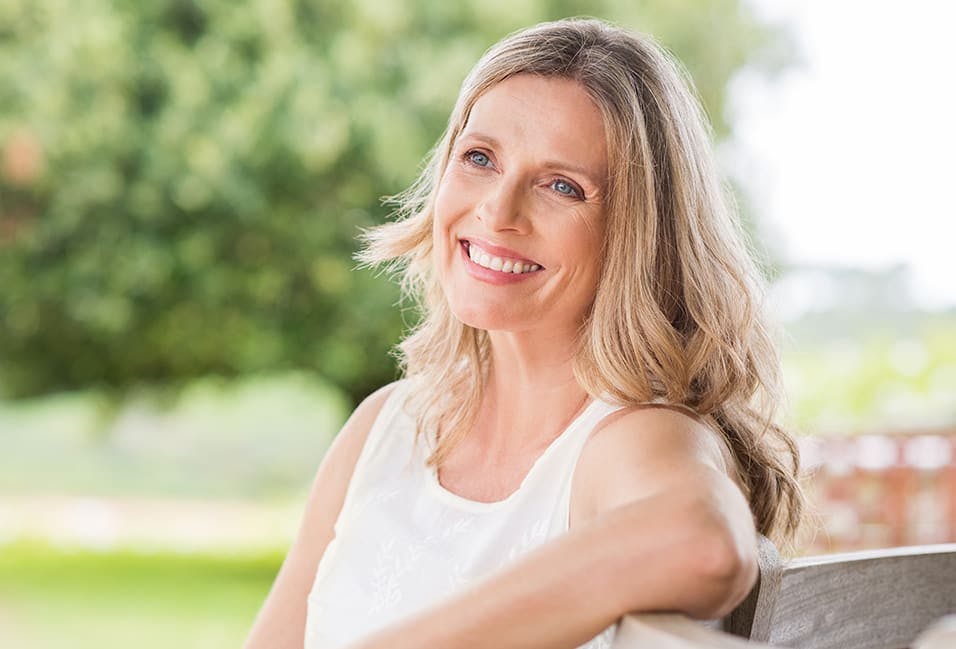 Woman Smiling with a Tree in the Background