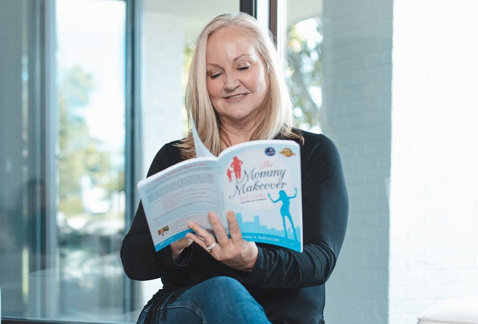 Woman Reading the Mommy Makeover Book