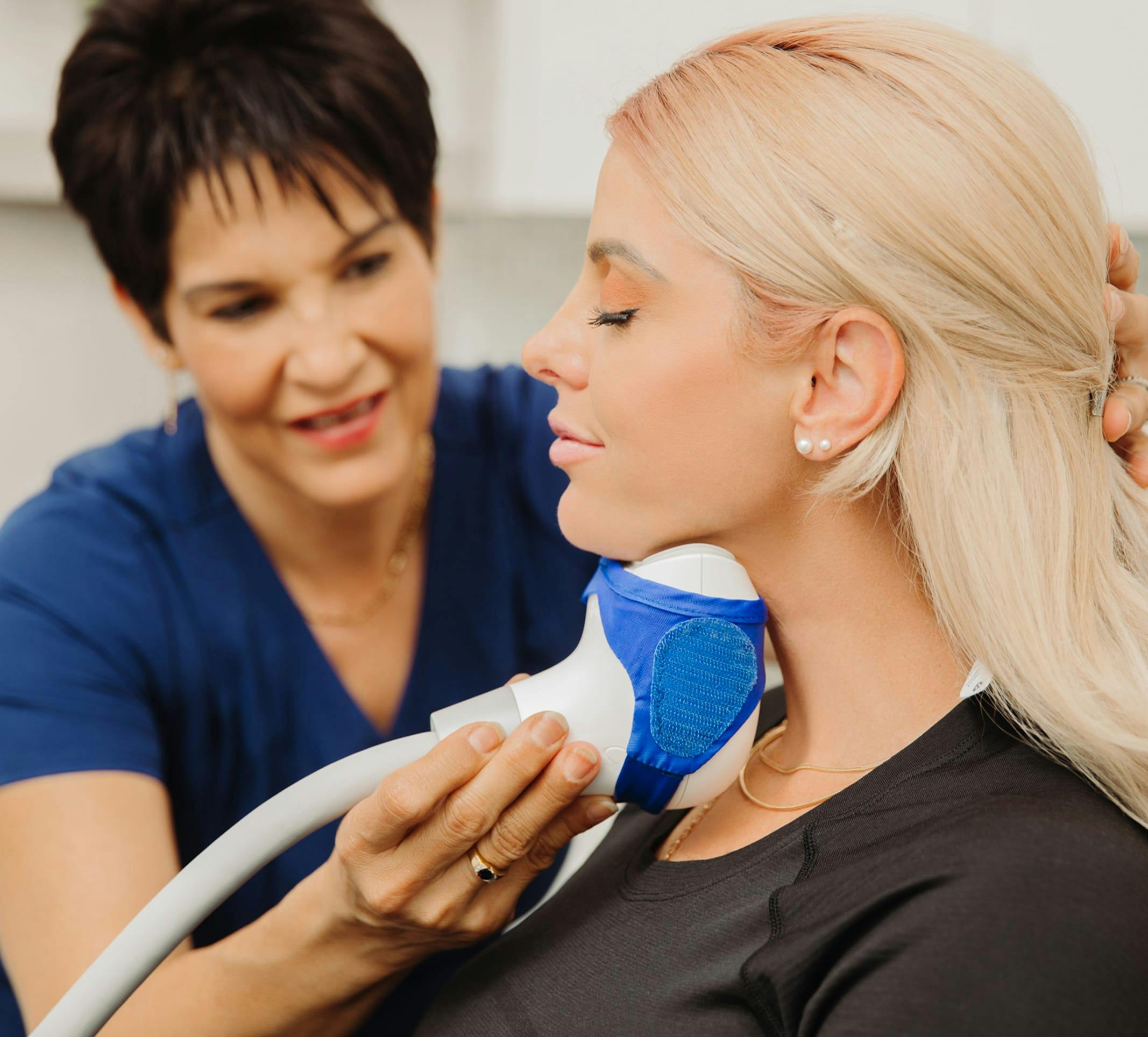 Female patient receiving CoolSculptin Elite treatment in her chin area at Flawless Med Spa in Albuquerque