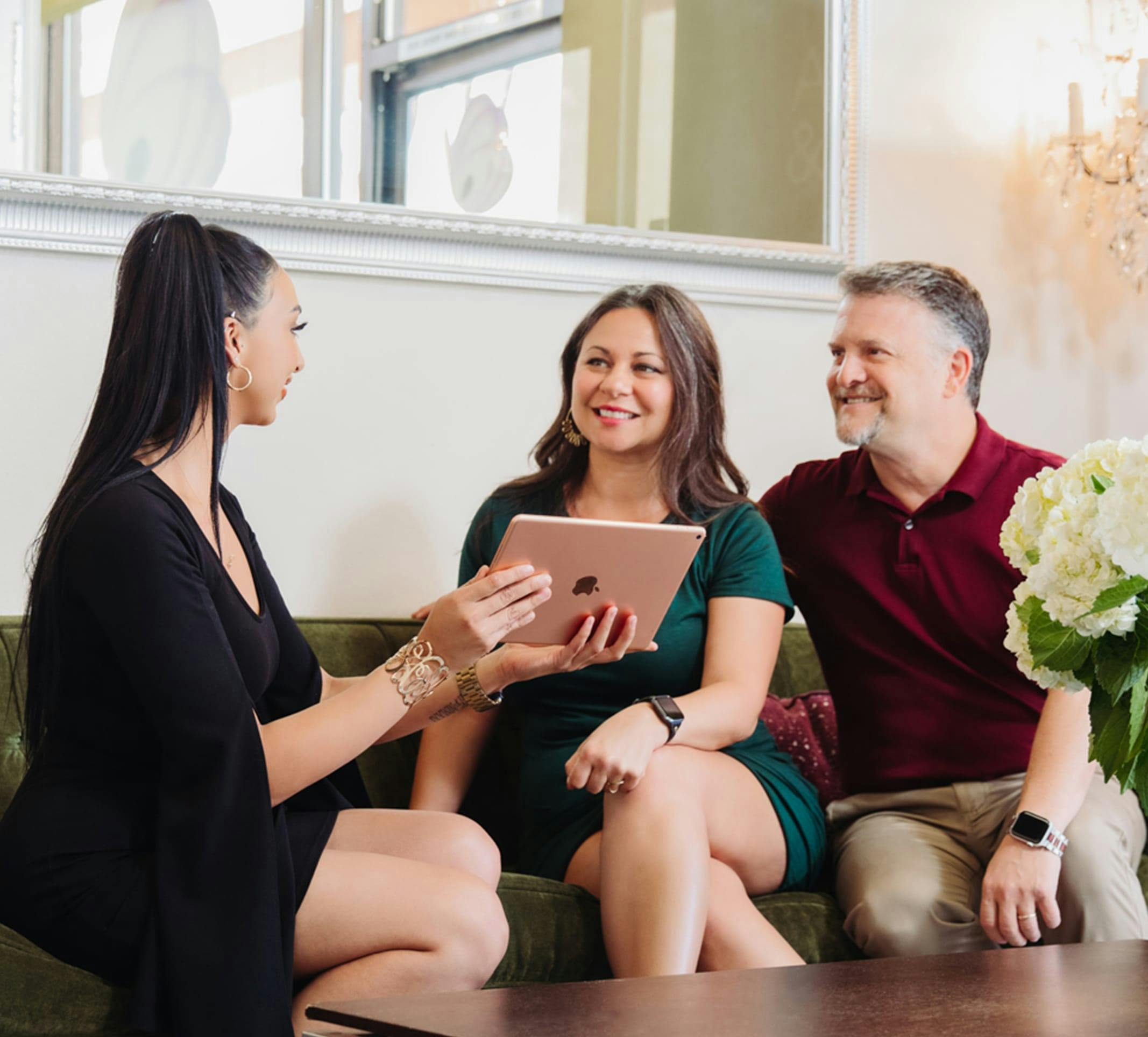 three people looking at a tablet