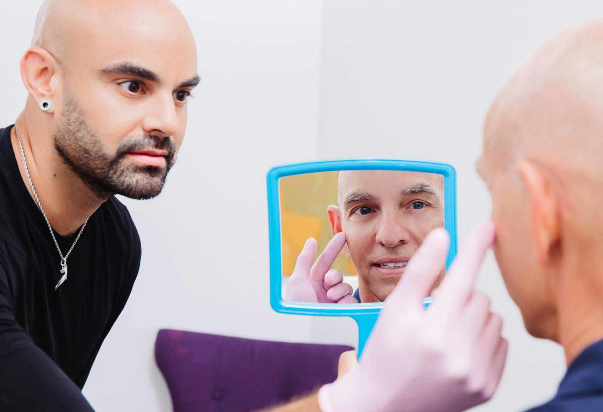 man looking in a handheld mirror